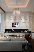 Open-plan living area with geometric wall panelling and chandelier