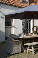 Covered garden table with parasol in the morning sun