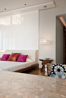 Modern bedroom furnishings with colourful satin cushions