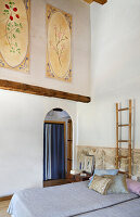 Bedroom with murals, wooden beams and ladder as decoration