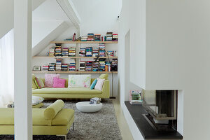 Dachgeschoss-Wohnzimmer mit Bücherregal und Kamin