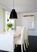 Light-coloured dining room furniture with tulips (Tulipa) on the table