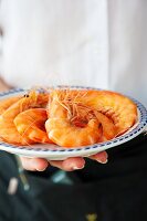 A waitress serving a plate of king prawns