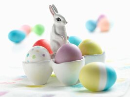 Bunte Ostereier in Eierbechern mit Osterhase