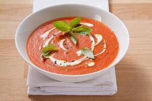 Cream of tomato soup garnished with creme fraiche and basil