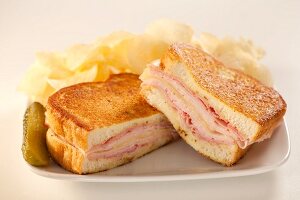 Monte Cristo Sandwich (Sandwichtoast mit Schinken, Pute und Käse), Chips und Essiggurke