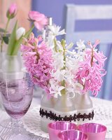 Pink and white hyacinths in small glass bottles