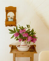 Beistelltisch aus Holz mit Waschschüssel und Rhododendron-Blüten