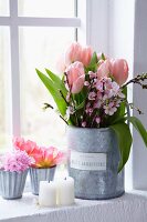 Tulips and twigs of peach blossom in large receptacle, tulips and pink hyacinths in zinc containers on window sill