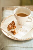 Cup of Coffee with Partially Eaten Diamond Shaped Pastry