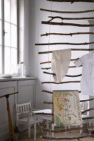 Hanging DIY ladder made from branches with children's clothes and picture book