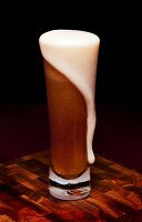 Glass Mug of Beer with Foam Spilling Over