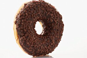 A doughnut with chocolate glaze and chocolate sprinkles