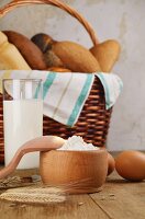 Brote im Brotkorb, Milch, Mehl und Eier