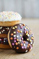 Gebackene Doughnuts mit dunkler und weisser Schokoglasur und Zuckersternen