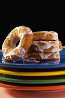 Key Lime Donuts with Cream Cheese Icing on a Stack of Multi-Colored Plates