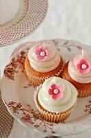 Three Vanilla Cupcakes with Pink Flower Decorations