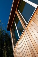 Wooden facade of contemporary wooden house with large windows