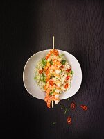Risotto with a skewer of prawns, spring onions and chilli