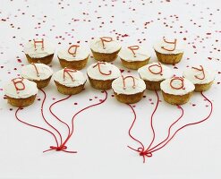 Cupcakes with white glaze and letters spelling out Happy Birthday