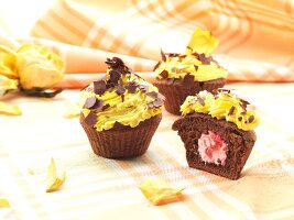 Chocolate cupcakes with strawberry cream filling, topped with lemon icing