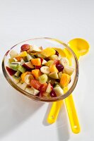 Gemischter Obstsalat mit Mango, Birne, Apfel, Kiwi, Trauben, Banane, Orangen und Grapefruit