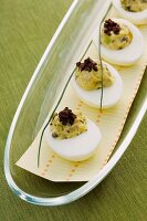 Russische Eier, garniert mit gehackten Oliven auf einer Platte
