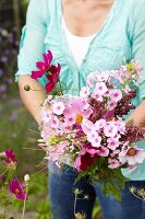 Frau pflückt Gartenblumen für einen Blumenstrauss