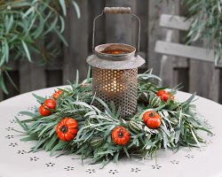 Lantern in centre of winter wreath of eucalyptus leaves and fruits on terrace
