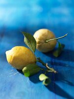 Lemons with leaves on a blue-painted wood surface