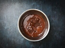 Partially Melted Chocolate Chunks in a Metal Bowl; From Above