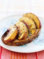 A Slice of Country Bread Topped with Sliced Nectarines and a Honey-Lemon-Poppy Glaze