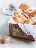 Fresh bread rolls in a wooden box with a linen cloth