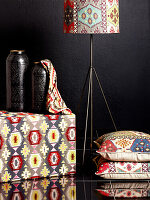 Stool with colourful upholstery, floor cushions and standard lamp