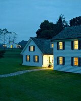 Woman on chair in front of house at dusk