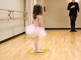 Kleines Mädchen mit Ballettkleid in einer Tanzstunde