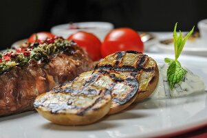 Grilled beef steak with herb butter and potatoes
