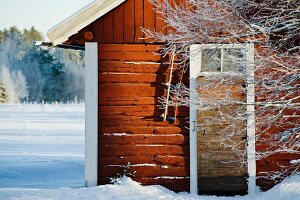 Swedish wooden cabin surrounded by snowy ground