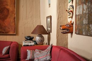 Ethnic masks on rustic wall in corner of living room
