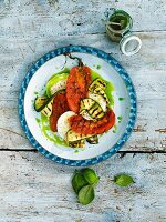 Salad with grilled tomatoes, courgette and basil oil