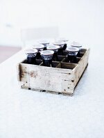 Several bottles of home-made elderberry juice in a wooden box