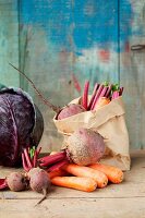 Rustic still life of vegetables, featuring carrots, beetroot and red cabbage