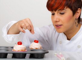 A woman decorating cupcakes