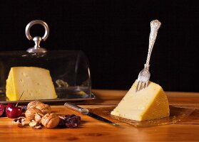 An arrangement of cheese with cherries and walnuts