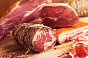 Various types of cooked meats in a butcher's shop