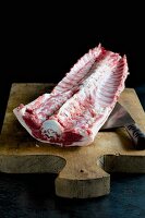 Saddle of lamb with bones on a chopping board