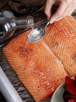 Cured salmon being prepared: salmon fillets being seasoned