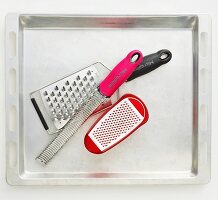 Various graters on a baking tray