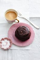 A mini Sachertorte with a cup of coffee