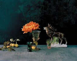 Autumnal still-life arrangement with stag ornament, crab apples & chrysanthemum